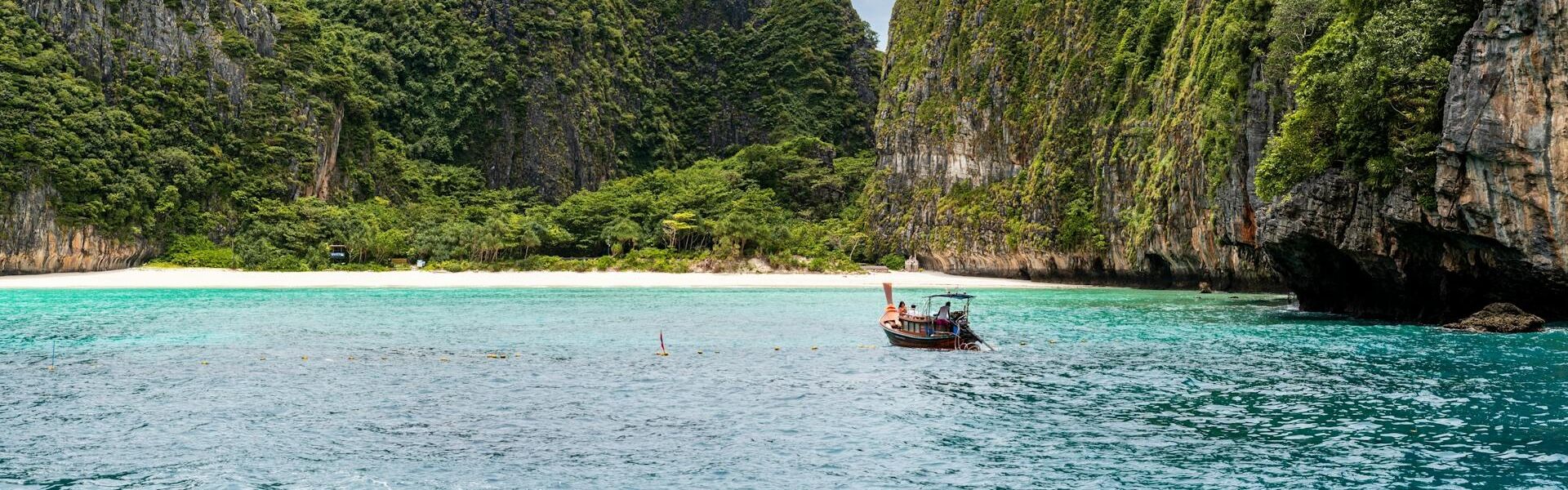 Serene Phi Phi beach sunset in Thailand on a Phi Phi Travel banner by Legend Travel Group.